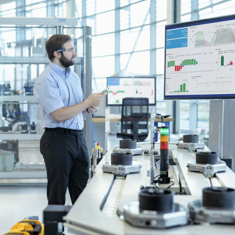 Engineer testing a robotic production simulator in robotics research facility